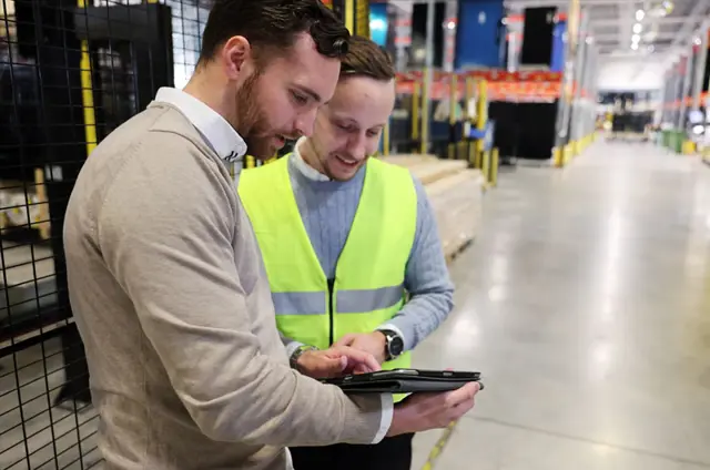 Två killar kollar på en iPad i en produktion