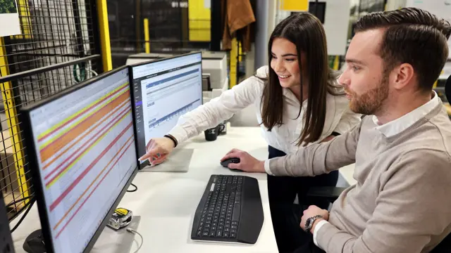 Två personer kollar på en datorskärm